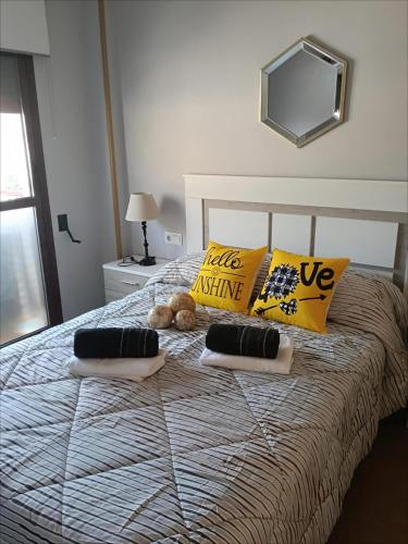 a bedroom with a bed with pillows and a mirror at Atico de lujo con jacuzzi, piscina y gimnasio cerca de Balneario de Archena in Villanueva de Río Segura