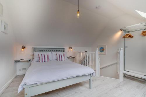 een witte slaapkamer met een wit bed met roze kussens bij 1 Bed in Padstow oc-p00730 in Padstow