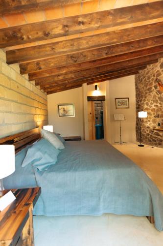 a bedroom with a large bed in a stone wall at Armadillo Mágico in Armadillo