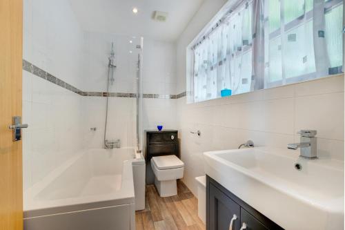 a bathroom with a tub and a toilet and a sink at Heylyn in Little Petherick