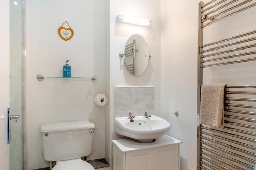 ein Badezimmer mit Toilette, Waschbecken und Spiegel in der Unterkunft Mariners Rest in Bideford