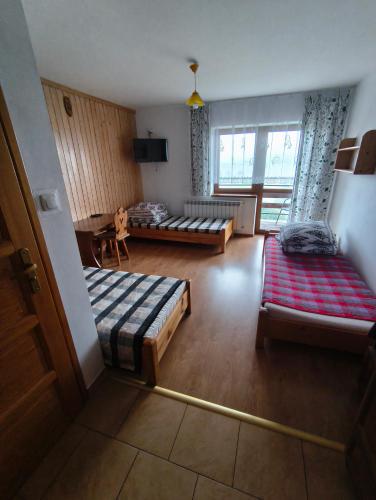 a living room with two beds and a couch at Wynajem Pokoi Maria Sowińska in Biały Dunajec