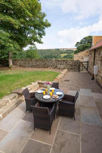 a patio with a table and chairs on a patio at Hog Barn at Howe End in Castleton