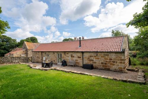 an exterior view of a stone house with a yard at Hog Barn at Howe End in Castleton