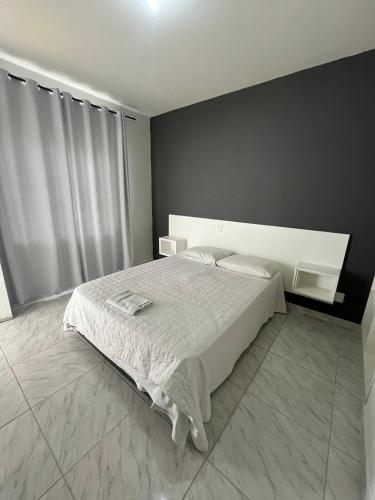 a bedroom with a bed and a black wall at Gentil Hotel in Florianópolis