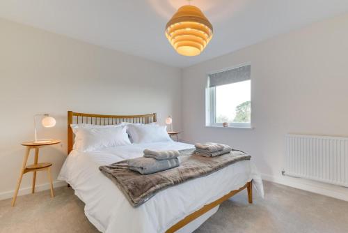 Un dormitorio blanco con una cama grande con toallas. en 3 Boathouse Terrace, en Saint Ervan