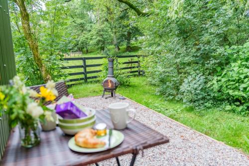 a picnic table with a plate of food on it at The Harmony Hut in Skirwith