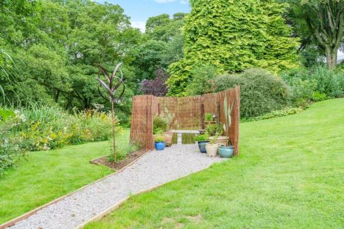 a garden with a fence and some plants at The Harmony Hut in Skirwith
