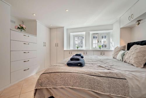 a bedroom with a large bed with white cabinets at Pearl Cottage - St Agnes in St. Agnes 