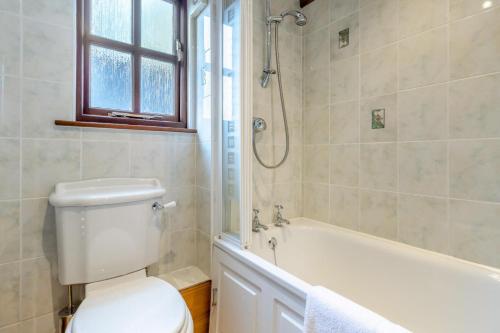 La salle de bains est pourvue de toilettes, d'une baignoire et d'une douche. dans l'établissement Coach House Cottage - Dorstone, à Dorstone