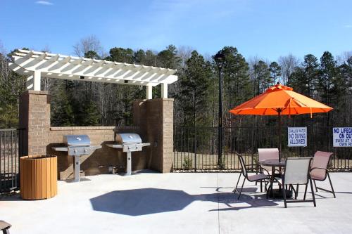 a patio with a table and an umbrella and a grill at Landing at Cove at Pine Ridge - 1 Bedroom in Lyman in Lyman