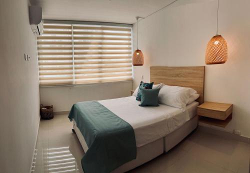 Un dormitorio con una cama grande y una ventana. en Escapate al sol en La Morada Peñazul apartamento BBQ, en Ricaurte