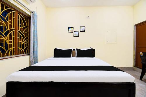 a bedroom with a large white bed with black pillows at Highway stay in in Bandha Chhada