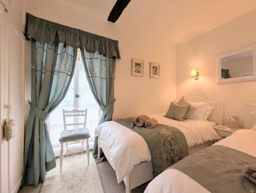 una camera da letto con due letti e una finestra di Mill Race Cottage a Chapel Stile