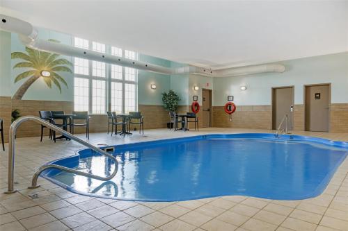 a pool in a hotel lobby with tables and chairs at Best Western Plus Woodstock Hotel Conference Centre in Woodstock