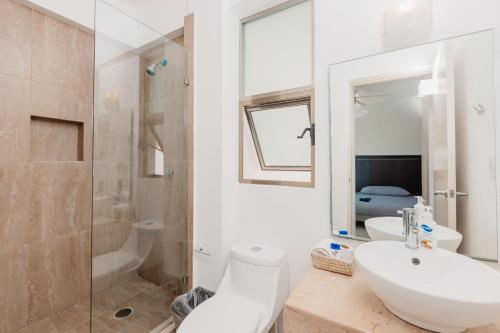 une salle de bain avec un lavabo, des toilettes et une douche dans l'établissement Best Riviera Maya Penthouses&Apartments, à Playa del Carmen