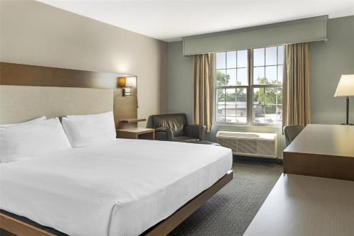 a hotel room with a large bed and a desk at Best Western Plus Woodstock Hotel Conference Centre in Woodstock
