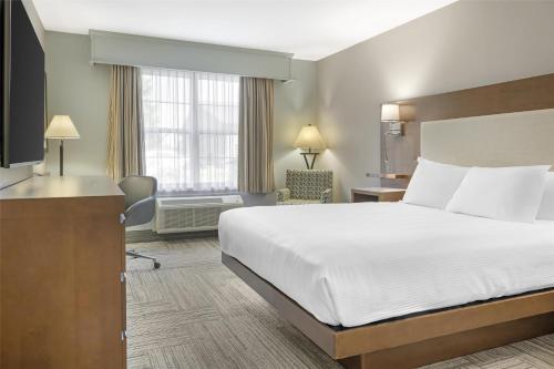 a hotel room with a bed and a desk at Best Western Plus Woodstock Hotel Conference Centre in Woodstock
