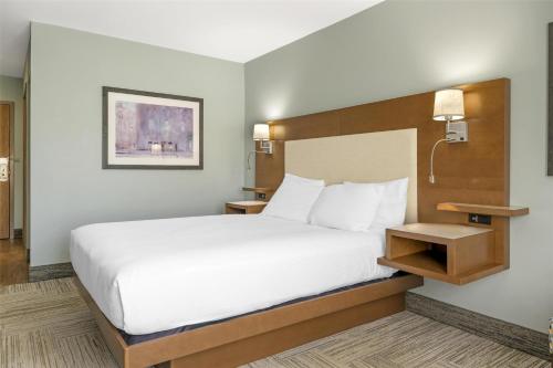 a hotel room with a large bed with white sheets at Best Western Plus Woodstock Hotel Conference Centre in Woodstock