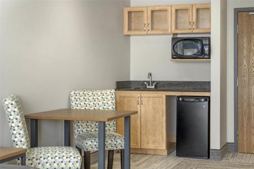 a kitchen with a table and chairs and a sink at Best Western Plus Woodstock Hotel Conference Centre in Woodstock