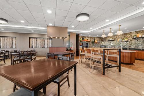 a dining room with wooden tables and chairs at Drury Plaza Hotel St Louis Creve Coeur in Creve Coeur