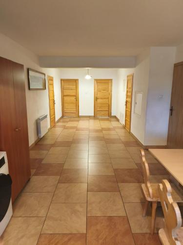 a hallway with wooden doors and a tiled floor at Wynajem Pokoi Maria Sowińska in Biały Dunajec