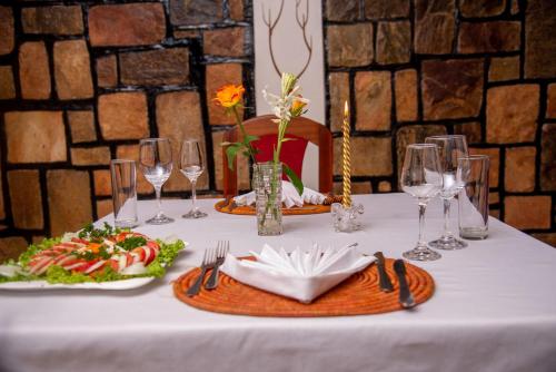a table with plates of food and wine glasses at Hotel Greenwich in Kigali