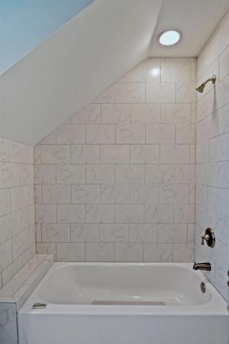a white bath tub in a white tiled bathroom at Marsh Views On Holly in Ebo Landing