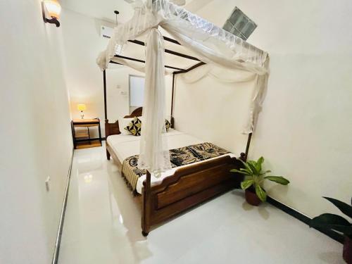 a bedroom with a bed with a canopy at Lucky Beach Mirissa in Mirissa
