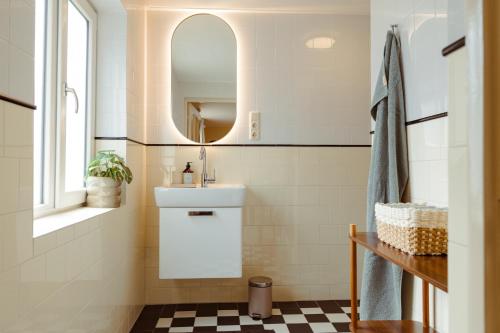 un baño con lavabo y espejo en Luxury Family Apartment with canal & Peperbus view, en Zwolle