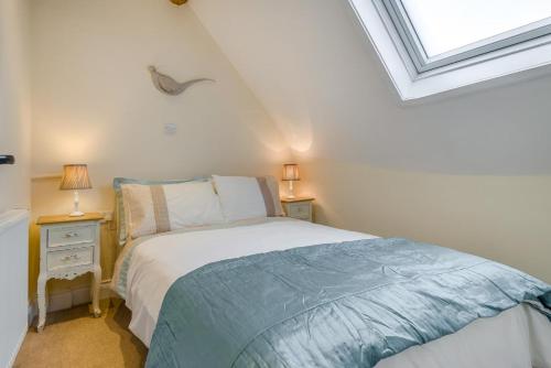 a bedroom with a bed and two night stands with lamps at The Cottage - Vineyard Street in Winchcombe