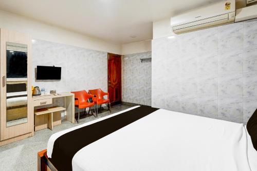 a bedroom with a bed and a desk and a television at Super Hotel O Arcot Road Porur in Chennai