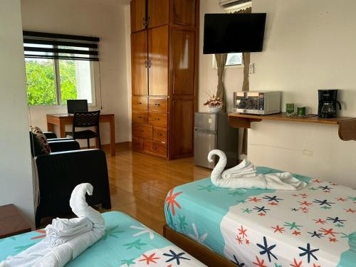 two swans sitting on beds in a living room at The Finch House (La Casa del Pinzón) in Puerto Ayora