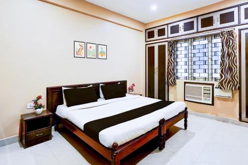 a bedroom with a bed and a window at Super Hotel O Chrompet Near Rela Hospital in Chennai