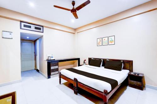 a bedroom with a bed and a ceiling fan at Super Hotel O Chrompet Near Rela Hospital in Chennai