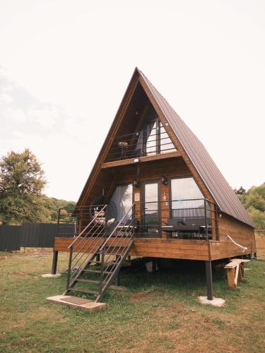 a large wooden house with a staircase in a field at NitsHouse! in Tsemi