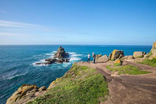 two people standing on a cliff near the ocean at The Studio at the Old Vicarage in Pendeen