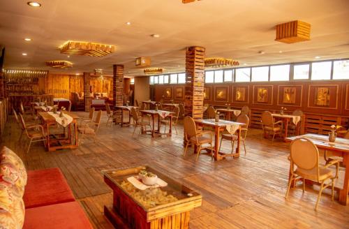 a restaurant with wooden floors and tables and chairs at Hotel Greenwich in Kigali