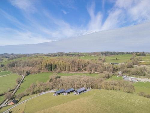 an aerial view of a farm with a group of houses at Aderyn Du in Berriew