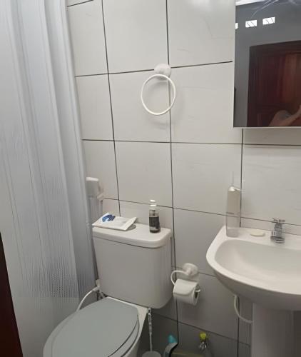 a white bathroom with a toilet and a sink at Orla de Macapá in Macapá
