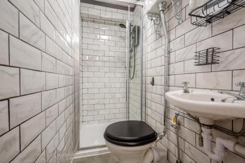 a bathroom with a black toilet and a sink at Trem Y Fam in Llanfairfechan