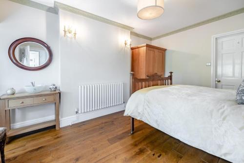 a bedroom with a bed and a mirror and a sink at The Gate Lodge Brynteg in Llanwenog
