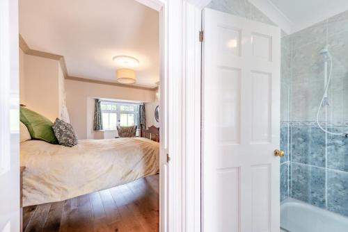 a bedroom with a bed and a shower and a tub at The Gate Lodge Brynteg in Llanwenog