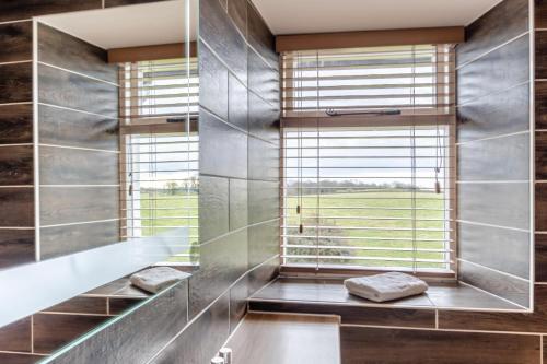 baño con ventana grande y bañera en Low Dog Kennel, en Cartmel