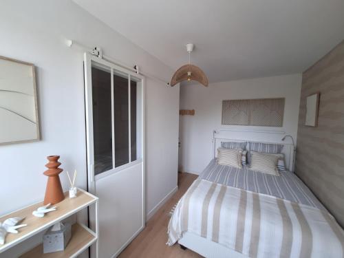 a bedroom with a bed and a large window at Villa du Rosais in Talmont-Saint-Hilaire
