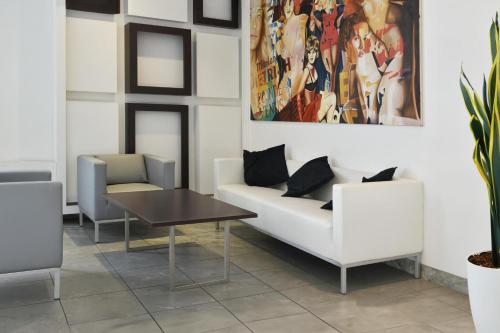 a living room with a couch and a table at B&B HOTEL Milano Cologno Studios in Cologno Monzese