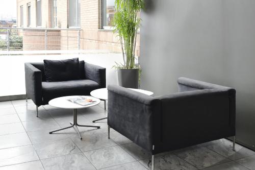 two chairs and a table in a room at B&B HOTEL Milano Cologno Studios in Cologno Monzese