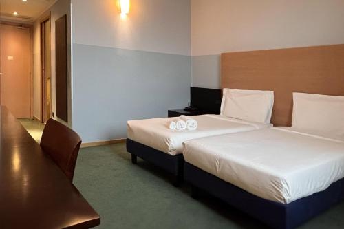 a hotel room with two beds with towels on them at B&B HOTEL Milano Cologno Studios in Cologno Monzese