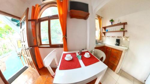 a small kitchen with a white table and chairs at The Finch House (La Casa del Pinzón) in Puerto Ayora