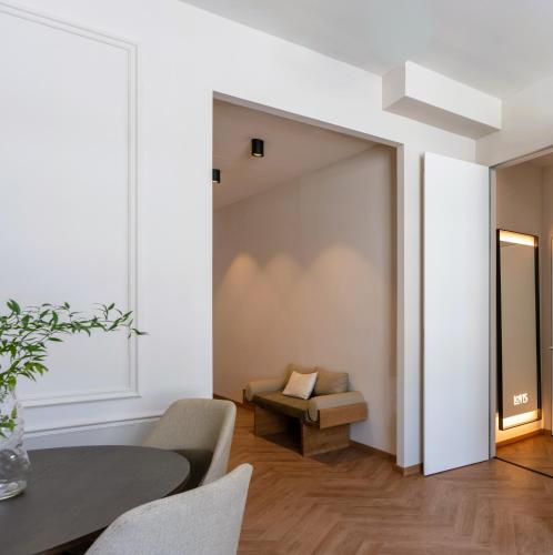 a living room with a sliding door with a table and chairs at LOVIS Suites Vienna in Vienna